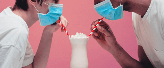 Two People Wearing Face Masks and Drinking a Milkshake